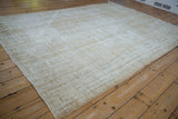 Textural detail of a distressed vintage Oushak rug corner, showing beige and cream pile.