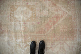 Distressed Oushak rug texture: worn pile, exposed foundation, and soft dusty rose colors.