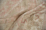 Distressed Oushak carpet pile showing foundation with faded dusty rose and ivory patterns.
