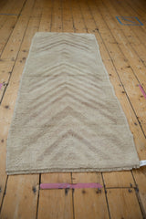 Distressed vintage Tulu rug runner with multi-tier arrowed design in muted tones.