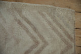 Textured pile of vintage distressed Tulu rug, revealing soft ivory and pale mauve arrowed pattern.