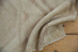Textured close-up of the distressed vintage Tulu rug pile in ivory and pale mauve.