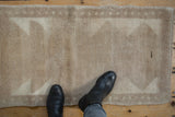 Vintage distressed Tulu runner in beige and ivory, with primitive triangular patterns and boots.