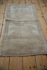 Distressed Tulu rug runner pile, showing primitive patterns in beige and sand tones.