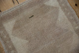 Distressed Tulu rug pile with subtle beige and sand tones, visible side selvage, and green mark.