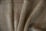 Close-up of vintage distressed Tulu rug's textured beige pile with visible knot heads.