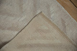 Distressed vintage Tulu rug pile in ivory, silver, and mauve, revealing its hand-knotted back.