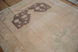 Distressed Oushak rug's pile texture, highlighting dramatic abrash, cream, and aubergine colors.