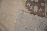 Underside weave of distressed Oushak rug with painted numbers and cream, aubergine pile.