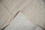 Distressed vintage Turkish Oushak rug with worn pile, visible foundation, and intact cord selvage.