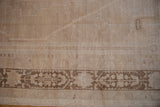 Evenly worn texture and floral cartouche border on a distressed vintage Oushak rug.