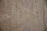 Hand-knotted construction visible on the reverse of the vintage distressed Oushak carpet.