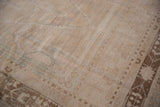 Evenly worn pile on a distressed Oushak rug showing exposed knot heads and faint foundation.