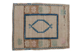 Distressed Oushak rug featuring a cream field, sapphire blue stepped medallion, and abrashed florals.