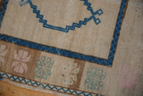 Distressed Oushak rug close-up: sapphire blue zig-zag, brown border, and pale floral motifs.