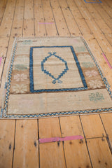 Distressed vintage Oushak rug corner with sapphire blue zig-zag and floral motifs.