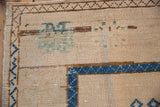 Distressed Oushak rug corner, sapphire blue and brown borders, textured pile with faded green motifs.