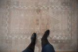 Textured, distressed vintage Oushak rug, featuring geometric patterns in soft silver and seafoam hues.