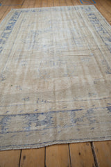 Angled perspective showing the distressed texture and worn knot heads of a vintage Oushak carpet.