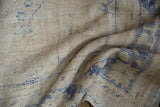 Close-up on the distressed Oushak carpet's nubby texture and exposed knot heads.