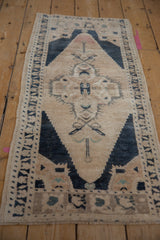Distressed Oushak runner pile with muted navy, peach, and ivory color variations.