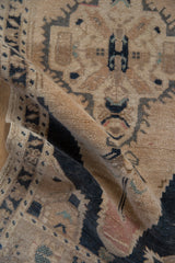 Distressed Oushak rug texture, showing faded navy, peach, and visible knot heads.