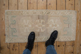 Vintage distressed Oushak rug's muted floral guls, abrashed field, and worn pile texture.