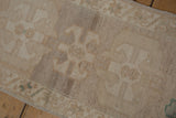 Distressed Oushak rug pile with abrashed muted beige and subtle green tones, even wear.