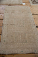 Distressed vintage Oushak rug's textured antique ivory pile with subtle faded teal patterns.