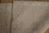 Distressed Oushak rug reverse, showing hand knotted foundation, natural tones, and intact side cord selvage.