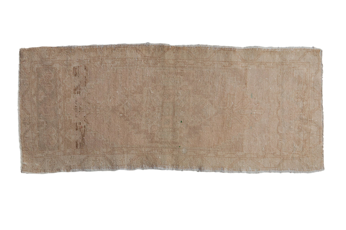 Distressed vintage Oushak rug with a faded diamond medallion in soft dusty blush and ivory tones.