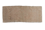 Distressed vintage Oushak rug with a faded diamond medallion in soft dusty blush and ivory tones.