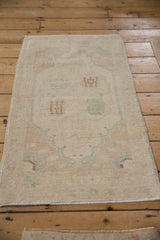 Distressed vintage Oushak rug runner, showing low pile, faint floral medallion, and muted seafoam green.