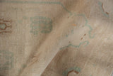 Distressed vintage Oushak rug texture with even wear, faded seafoam green, and antique ivory.