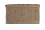 Distressed vintage Oushak rug mat featuring a faded neutral field, 1'10