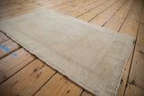 Distressed vintage Oushak rug showcasing faded ivory tones and textured pile.
