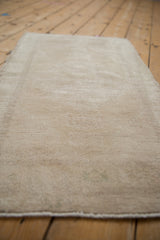 Distressed vintage Oushak rug, low pile texture in antique ivory and faded sand.