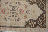 Even wear across knot heads on a distressed Oushak rug showing the brown corner spandrel.