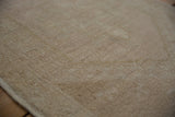 Distressed Oushak rug pile texture, showing even wear in antique ivory and pale copper.