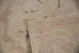 Distressed vintage Oushak rug pile revealing knot heads and hand-knotted foundation with selvage.