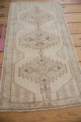 Quatrefoil blossom and serrated geometric pattern on a distressed Oushak rug, ivory and faded blue.