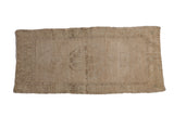 Distressed Oushak rug mat with a faded stepped medallion in antique ivory and beige.