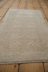 Subtle starburst floral motifs and even pile texture on the vintage Oushak mat.