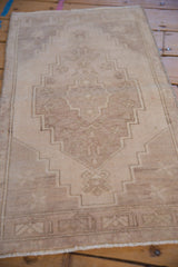 Faded stepped medallion and starburst pinwheel motifs on a distressed Oushak rug.