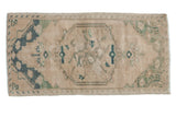 Distressed vintage Oushak rug mat, abrashed floral medallion in cream, seafoam, and dusty teal.