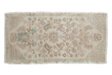 Vintage distressed Oushak rug with a faded allover floral design in seafoam green, beige, and ivory.