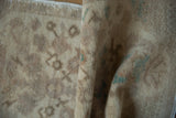 The low, evenly worn pile of a vintage Turkish Oushak rug with soft seafoam details.