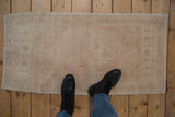 Distressed vintage Oushak runner, faded medallion and floral fills on abrashed pink and ivory ground.