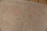 Short, even pile and abrashed antique ivory ground of a vintage Oushak rug.