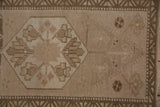 Distressed Oushak rug with visible pile wear, dusty rose floral motif, abrashed field.
